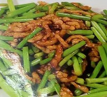 Stir-fried pork strips with garlic shoots