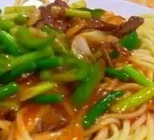 Stir-fried garlic shoots with pork over rice