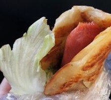 Egg-filled pancake with grilled sausage